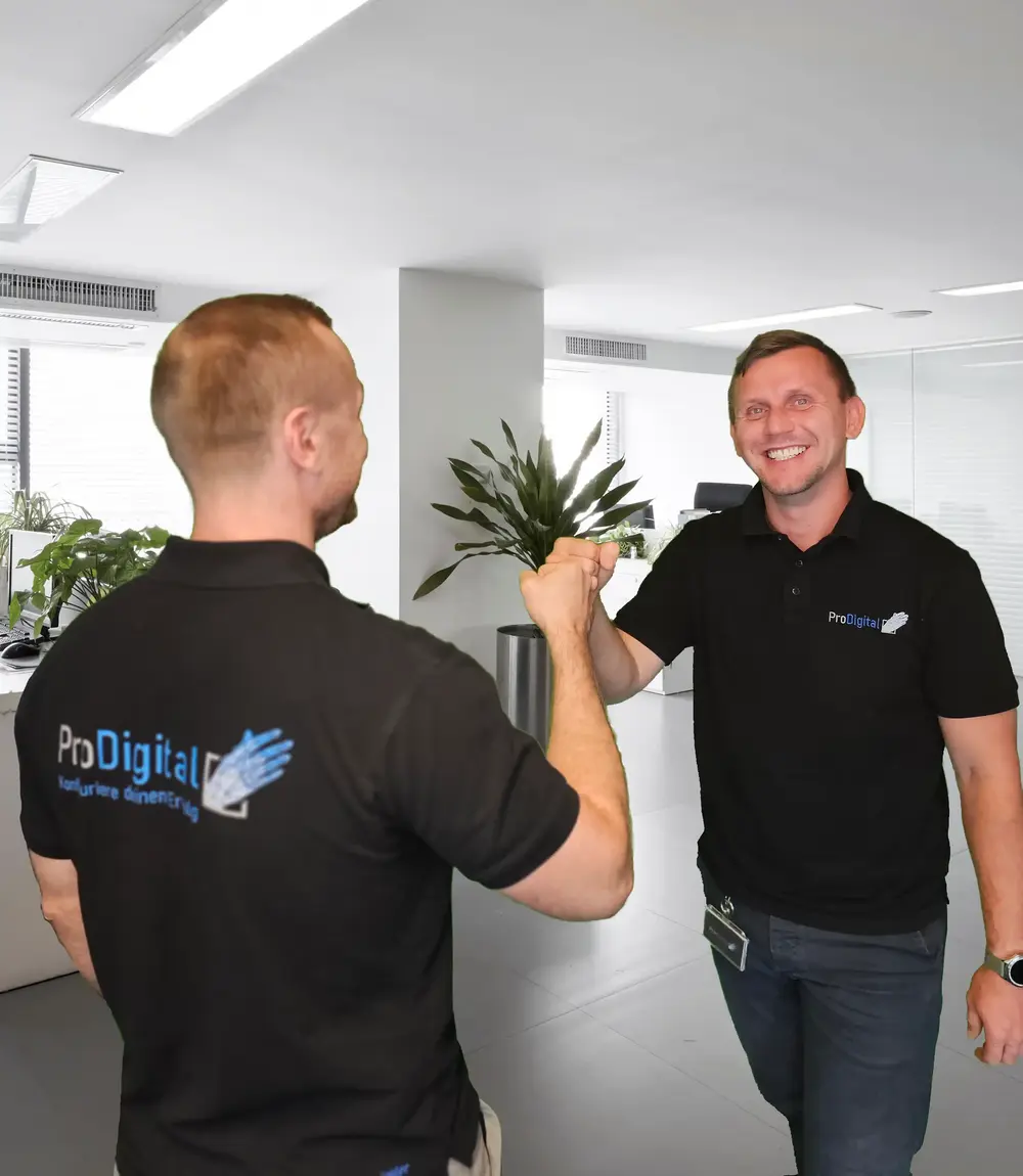 Two colleagues wearing ProDigital shirts greet each other