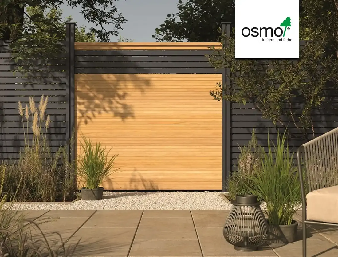 Sichtschutzzaun mit dunkler Lamellenverkleidung und heller Holz-Torfläche in gepflegtem Garten, mit Osmo-Logo.