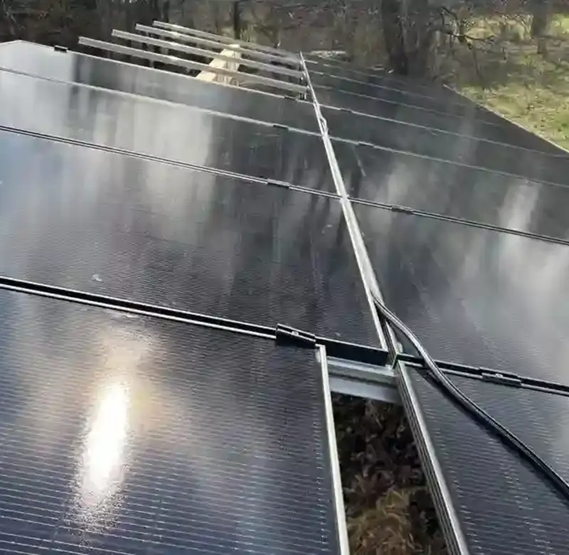 Nahaufnahme installierter Solarmodule auf Aluminium-Unterkonstruktion mit sichtbarer Verkabelung