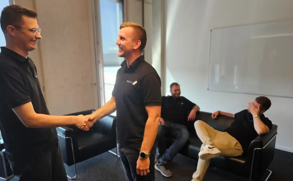 Kollegen im Gespräch und zwei geben sich die Hand